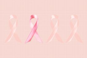 Cuatro cinta de cáncer de mama sobre el fondo rosa. Una de las cintas es el color, y las otras tres se mezclan con el fondo.