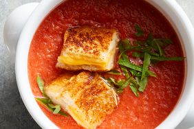 Foto superior de un plato de sopa de tomate con picatostes de queso asado