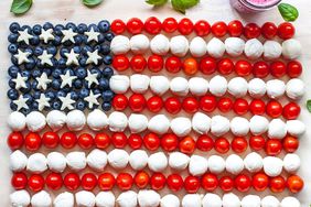 Súper foto de la bandera estadounidense hecha con tomates cherry, bolas de mozzarella y arándanos.