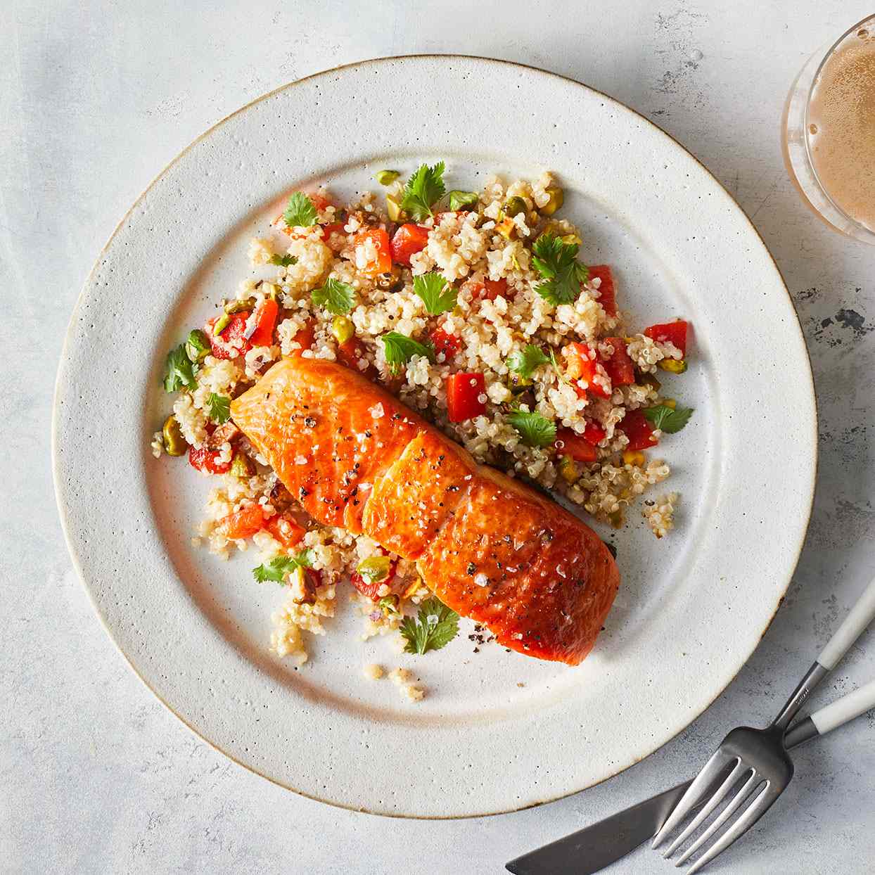 Plato blanco con ensalada de salmón y quinoa.