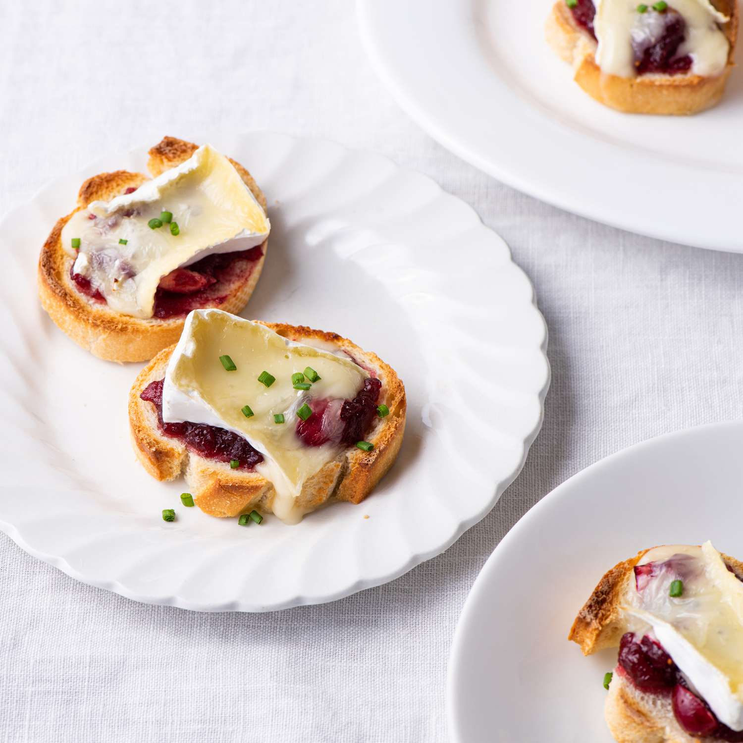 Foto de receta de 3 capas de Cranberry Brie Crostini en platos pequeños