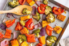 Una foto de una receta de coloridas verduras de hoja asadas en una bandeja para hornear galletas.
