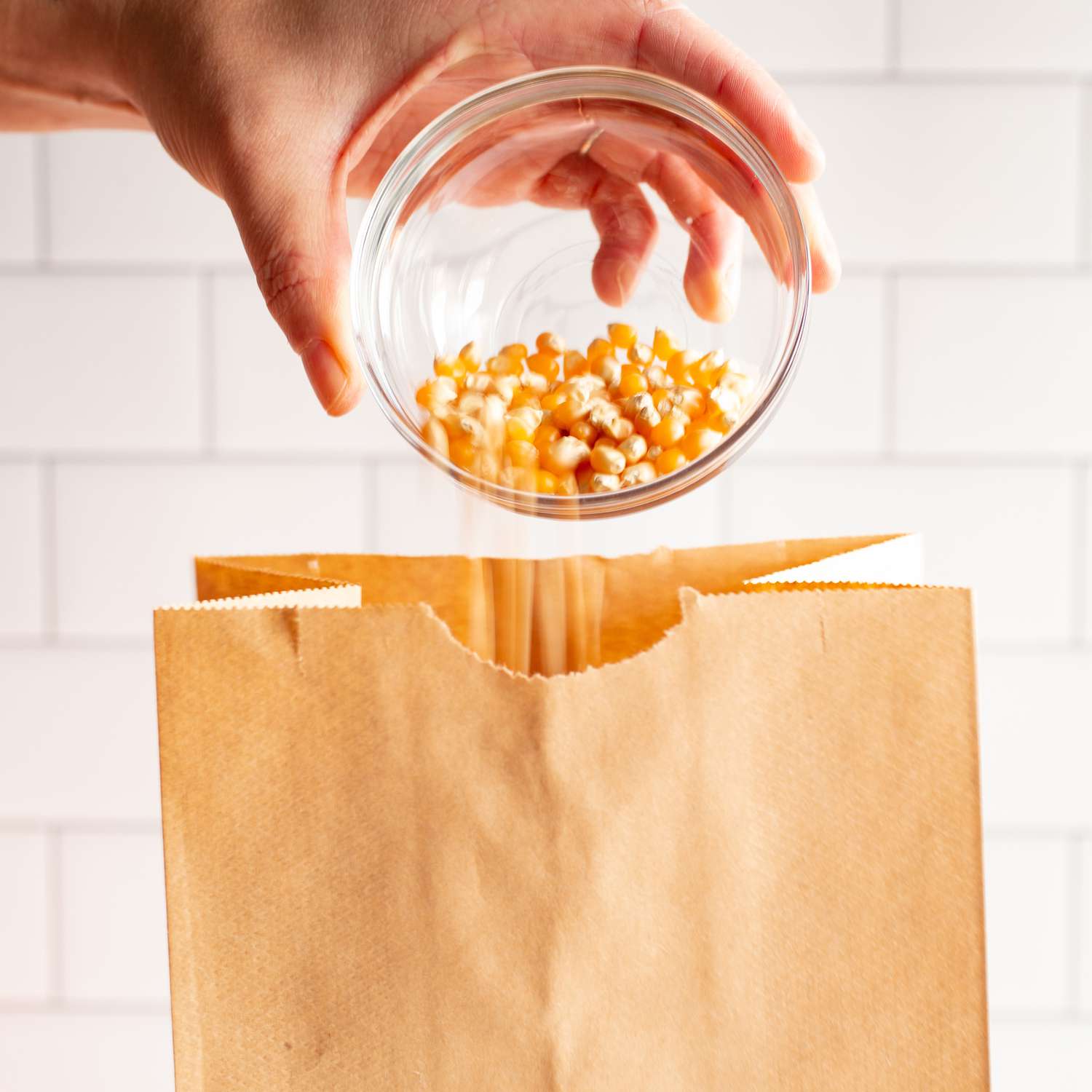 Manos para soltar nueces de palomitas de maíz en bolsas de papel