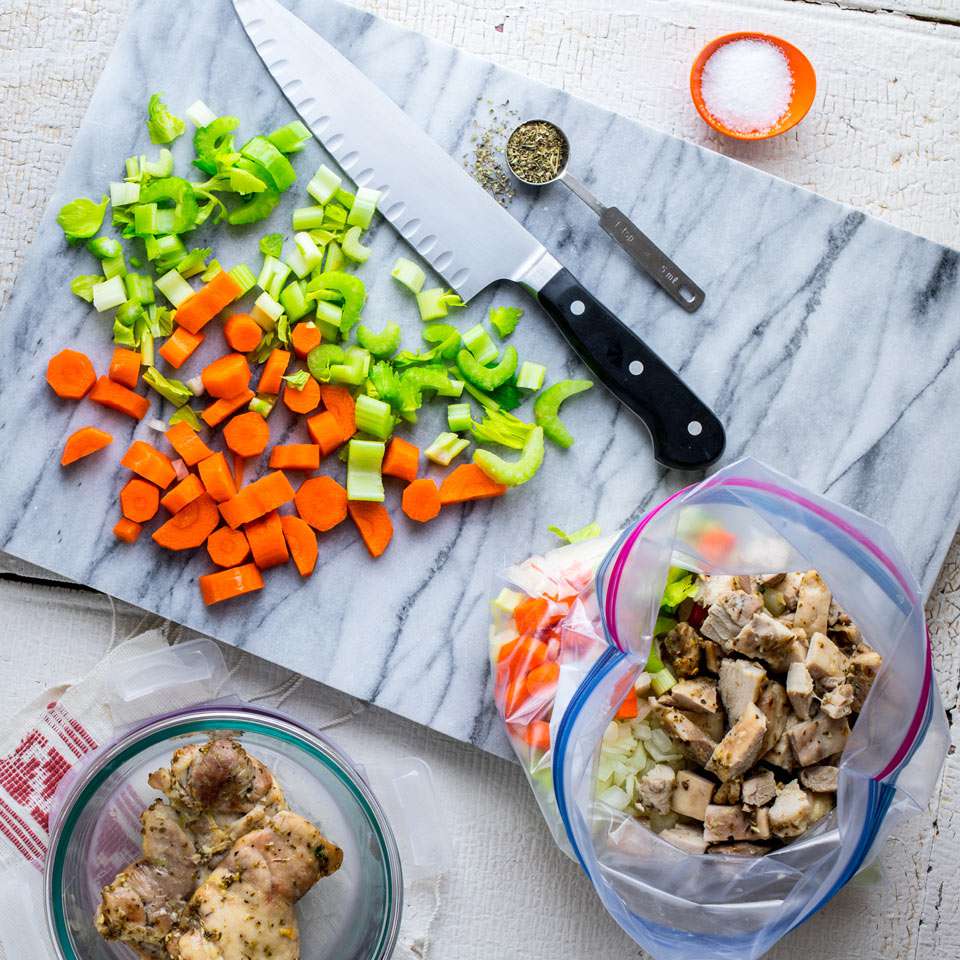 Tabla de cortar de madera y verduras picadas, pollo picado y bolsas de plástico - tienda de preparación de comidas